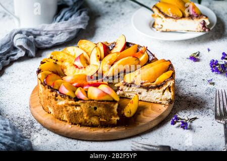 Cheesecake Di New York Con Pesche. Cheesecake mascarpone. Cibo sano. Dessert con frutta. Torta estiva. Ancora vita di cibo. Pezzo di torta Foto Stock