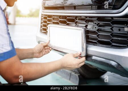 Tecnico che modifica il numero di targa della Thailandia nel centro di assistenza Foto Stock