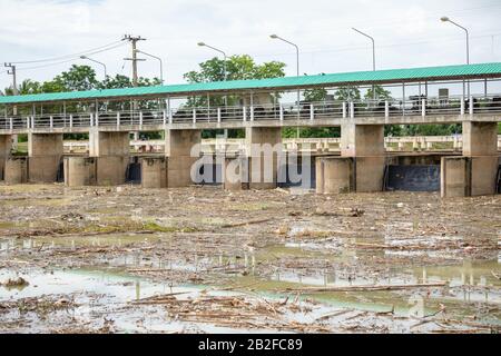 Molti rifiuti nel fiume e bloccati vicino alla porta principale della diga Foto Stock