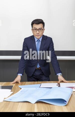 Uomo in piedi dietro la scrivania Pechino Cina Foto Stock