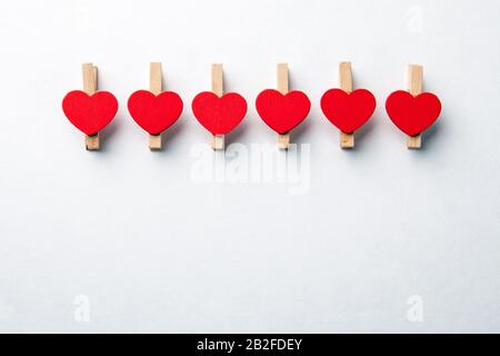 Clip in legno con cuore rosso. Sfondo bianco con spazio di copia. Forniture Per Ufficio Foto Stock