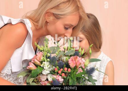 Mamma con sua figlia in abiti bianchi in studio. Foto Stock