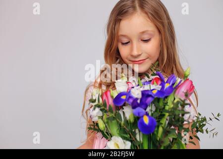 Carina bambina con fiori nelle mani Foto Stock