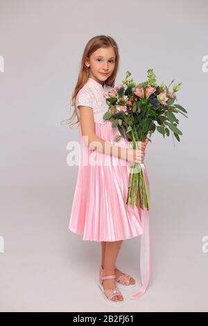 Carina bambina con fiori nelle mani Foto Stock