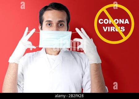 Medico asiatico uomo in guanti protettivi che indossano influenza. Prevenire la malattia influenzale Coronavirus Foto Stock