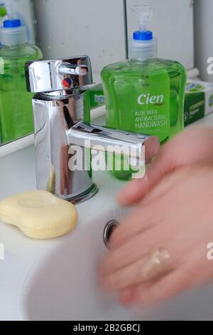 Uomo che lava le mani in bagno con acqua e sapone. Foto Stock