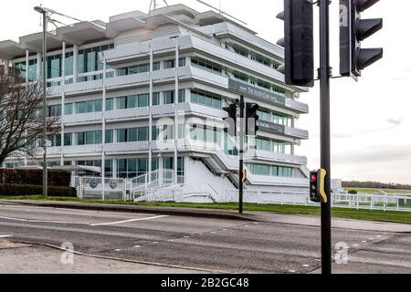 Una traversata in pellicano per cavalli e cavalieri si trova davanti al Queens Stand e al Lester Piggott Gates all'ippodromo di Epsom Downs, Surrey, Inghilterra. Foto Stock