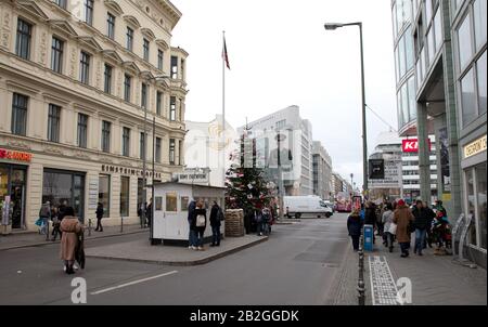 Berlino, Germania - 20 dicembre 2019: la gente visita famoso Checkpoint Charlie a Berlino. Durante la Guerra fredda era il più noto che attraversa Berlino Wa Foto Stock