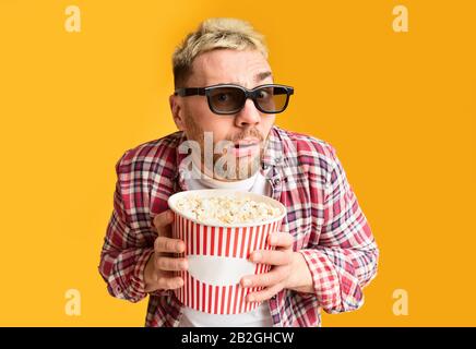 Serata di cinema. Sorpreso ragazzo divertente tenuta a secchio Foto Stock