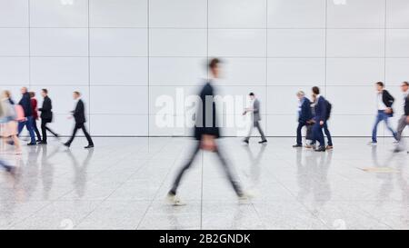 Molti viaggiatori anonimi di affari sfocati vanno in aeroporto o conferenza Foto Stock