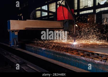 Taglio al plasma di metallo con un cnc. Macchina da taglio al plasma per il taglio di lamiere di acciaio. Taglierina laser in produzione. Taglio di metalli industriali con laser al plasma. Le scintille volano dal laser Foto Stock