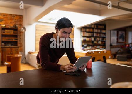 Giovane uomo che usa un touchpad a casa Foto Stock