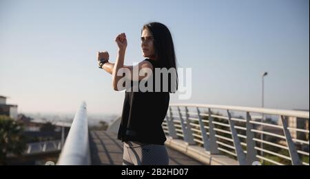 Vista laterale donna che si allunga prima di correre Foto Stock