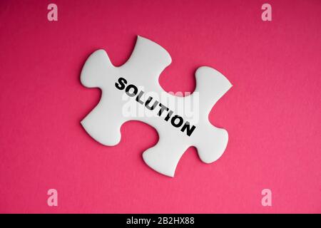 Testo della soluzione con puzzle bianco su sfondo rosa. Concetto di business e motivazione Foto Stock