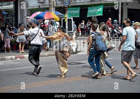 Attraversando la strada. La famiglia indiana asiatica attraversa la strada e tiene le mani per fermare il traffico in arrivo. Thailandia Sud-Est Asiatico Foto Stock