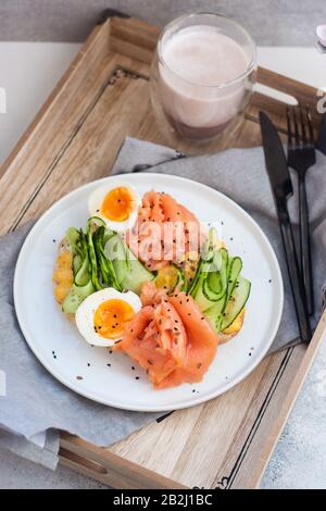 Salmone affumicato, formaggio spalmabile e toast al cetriolo con uova bollite. Foto Stock