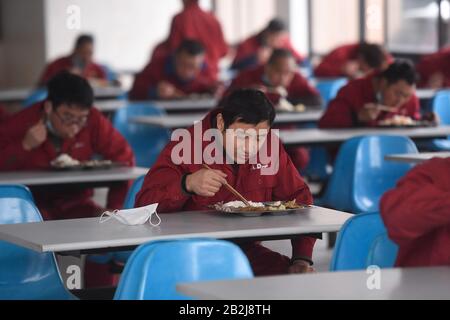 (200303) -- DEQING, 3 marzo 2020 (Xinhua) -- I Lavoratori hanno pasti sotto il principio di "una persona una tabella" nella sala da pranzo di Zhejiang Dingli Machinery Co., Ltd. Nella contea di Deqing, nella provincia di Zhejiang della Cina orientale, 3 marzo 2020. Deqing County ha lanciato politiche per aiutare le imprese a riprendere il lavoro durante la lotta contro la nuova epidemia di coronavirus. Tutte le 781 imprese al di sopra delle dimensioni designate in Deqing hanno ripreso la produzione e il funzionamento entro lunedì. (Xinhua/Huang Zongzhi) Foto Stock