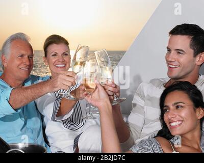 Coppia giovane e di mezza età che si rilassa sulla barca con champagne Foto Stock