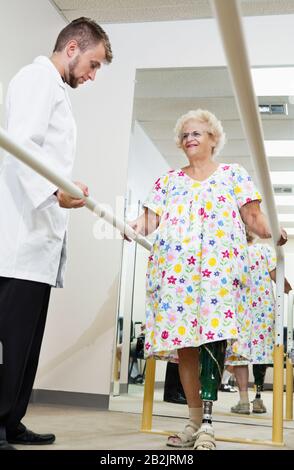 Tecnico che osserva la donna anziana che ha terapia ambulatoriale Foto Stock