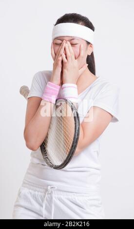 Giovane tennista femminile con mani sul viso su sfondo bianco Foto Stock