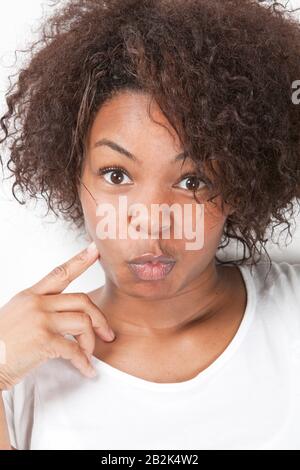 Ritratto di giovane donna afroamericana che fa volti divertenti Foto Stock