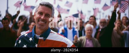 Ritratto dell'uomo felice medio-adulto con la folla che celebra il giorno dell'Indipendenza (USA) Foto Stock