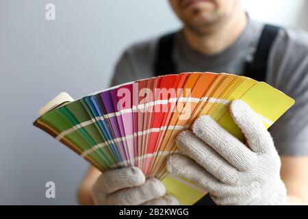 Giovane riparatore che tiene la tavolozza luminosa dei colori per i particolari interni Foto Stock