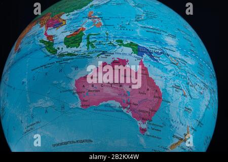 Australia - Marzo 2020. Globo con nomi geografici russi isolati su bacground nero Foto Stock