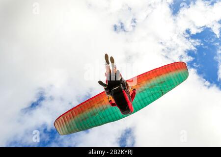 Bassa Angolazione di un parapendio in tandem del team su il decollo Foto Stock