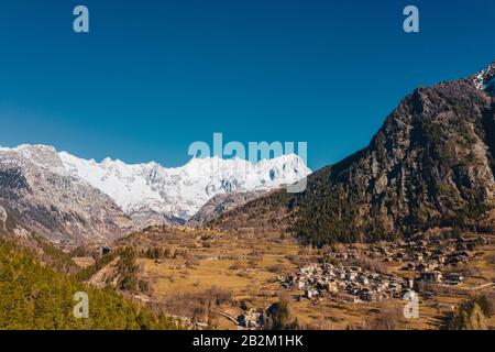 Il villaggio di Palleusieux sotto una grande montagna, nel Bacino Pre-Saint-Didier, Valle d'Aosta, Italia Foto Stock