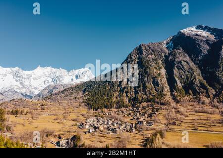 Il villaggio di Palleusieux sotto una grande montagna, nel Bacino Pre-Saint-Didier, Valle d'Aosta, Italia Foto Stock