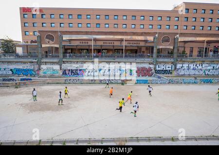 Persone che pagano il calcio nel fiume essiccato Rio Guadaimedina. Foto Stock