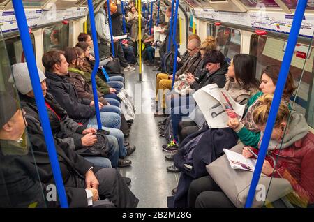 Pendolari che viaggiano su una linea di Piccadilly carrozza del treno della metropolitana di Londra, Regno Unito Foto Stock