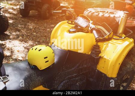 Casco giallo su un ATV nella foresta, nel fango. Ruote ed elementi di veicoli fuoristrada in fango e argilla. Attività di svago, sport e turismo. Es Foto Stock