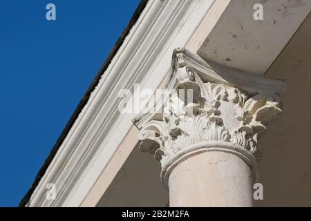 Elemento di una vecchia colonna di ioni contro un cielo blu. Elemento vintage dell'edificio. L'elemento della colonna bianca sotto il soffitto Foto Stock