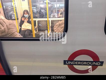 Una donna sulla linea District della rete metropolitana di Londra indossando un facemask protettivo il giorno in cui il segretario di Heath Matt Hancock ha detto che il numero di persone diagnosticate con coronavirus nel Regno Unito è salito a 51. Foto PA. Data Immagine: Martedì 3 Marzo 2020. Vedi la storia di PA SALUTE Coronavirus. Photo credit dovrebbe leggere: Kirsty o'Connor/ PA Wire Foto Stock