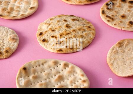 Matzah fatta a mano per Pasqua ebraica su sfondo rosa Foto Stock