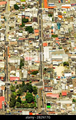 Una fotografia aerea dall'alto cattura un quartiere urbano densamente popolato caratterizzato da edifici raggruppati con vari colori e materiali del tetto. Un parco verde centrale con alberi Foto Stock