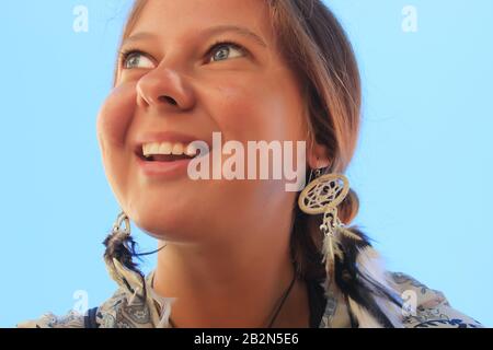 Giovane ragazza con capelli rossi ed orecchini a forma di catchers da sogno carino sorridente e guardare in su Foto Stock