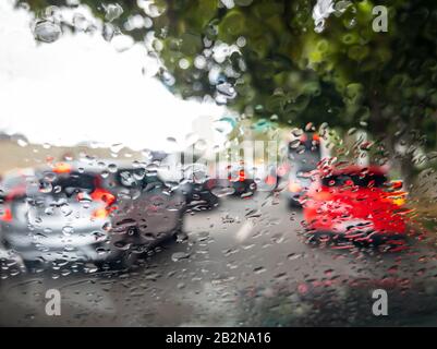 Traffico e pioggia sul vetro dell'auto. Traffico nella grande città. Foto Stock