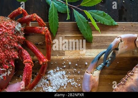 Granchio marrone bollito e granchio ragno nella tavola di legno della cucina, deliziosa preparazione di pesce Foto Stock