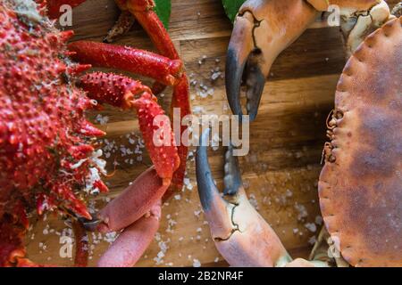 Granchio marrone bollito e granchio ragno nella tavola di legno della cucina, deliziosa preparazione di pesce Foto Stock