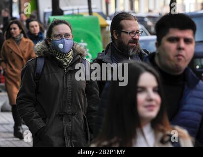 Una donna in una maschera protettiva cammina lungo la strada come un mezzo di protezione contro la minaccia.Vice Ministro della Salute dell'Ucraina e il capo medico sanitario del paese, Viktor Lyashko ha riferito il primo caso confermato di un nuovo coronavirus, Covid-19 in Ucraina. Secondo il Ministero della Salute, il 29 febbraio un uomo è stato ricoverato nella città di Chernivtsi, prima di questo, aveva visitato l'Italia durante un viaggio turistico. Foto Stock