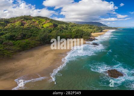 Immagine panoramica aerea al largo della costa sulla spiaggia di Lumaha'i sull'isola hawaiana di Kauai con montagne Na Pali dietro Foto Stock