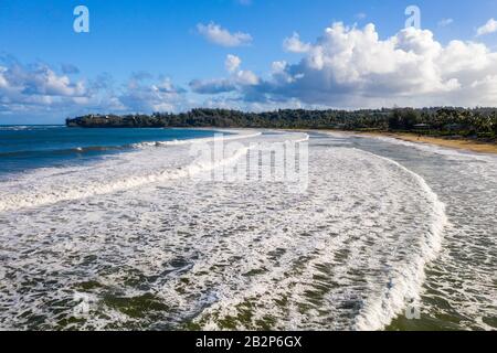 Immagine panoramica aerea all'alba al largo della costa sulla Baia di Hanalei e Princeville dal parco spiaggia di Waioli sull'isola Hawaiiana di Kauai Foto Stock