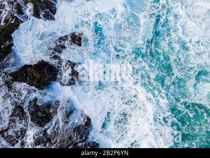 Vista aerea dei droni sulle onde che si infrangono sulle rocce sulla spiaggia di Lumaha'i, sulla sponda nord di Kauai Foto Stock