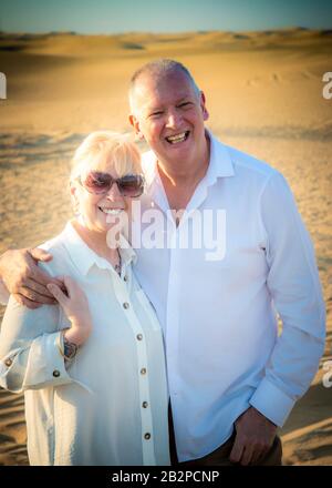 coppia ritirata in piedi insieme nel deserto, come il sole sta scendendo. Foto Stock