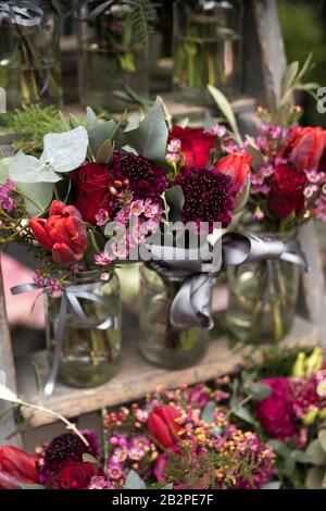 Una varietà di colori vicino al negozio Liberty di Londra. Grandi bouquet in vasi di stagno. Piccoli bouquet per diverse occasioni Foto Stock