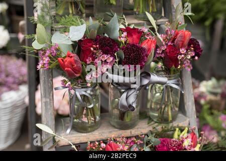 Una varietà di colori vicino al negozio Liberty di Londra. Grandi bouquet in vasi di stagno. Piccoli bouquet per diverse occasioni Foto Stock