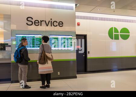 Coppia che guarda il PROGRAMMA GO Transit presso una stazione di servizio a Union Station Toronto. Foto Stock